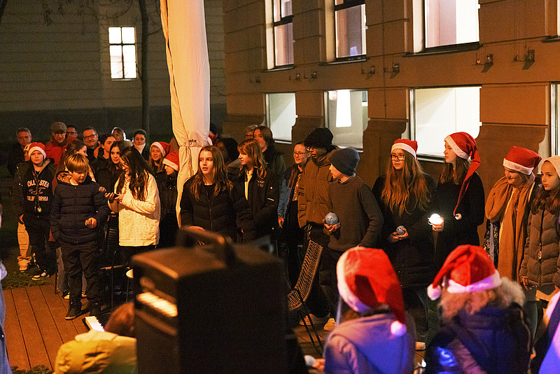 Chor der PMS mit Weihnachtsmützen und Lichtern in der Hand im Innenhof der PHSt