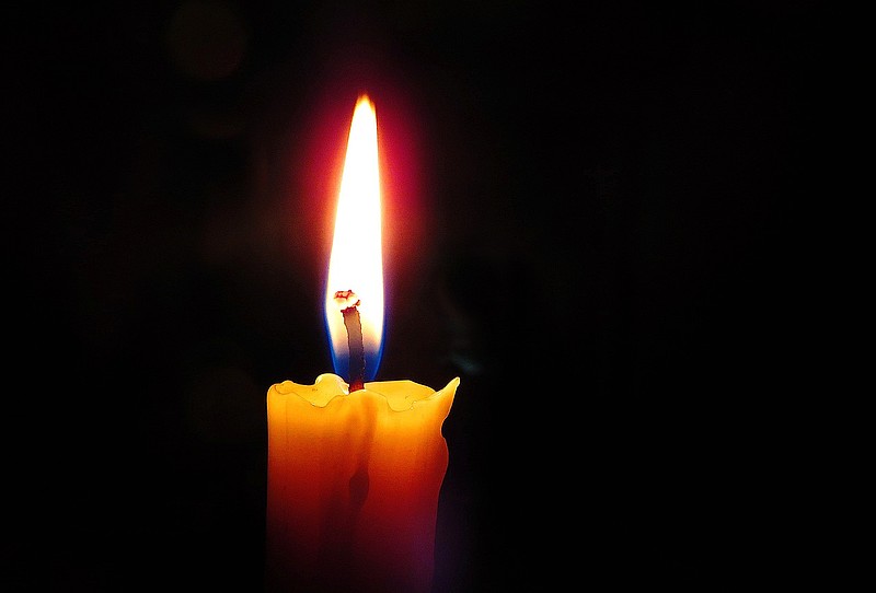 brennende Kerze auf schwarzem Hintergrund